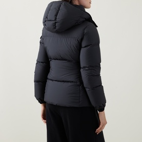 Model wearing Moncler black hooded puffer jacket, rear view, styled with black wide-leg trousers