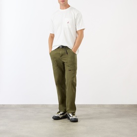 Model wearing Gramicci Gadget Belted Trousers in olive, straight-cut leg with adjustable belt, styled with a white T-shirt and hiking trainers.