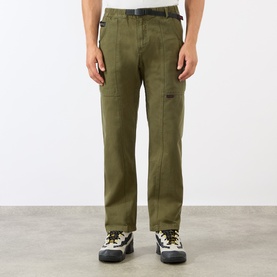 Model wearing Gramicci Gadget Belted Trousers in olive, straight-cut leg with adjustable belt, styled with chunky hiking boots.