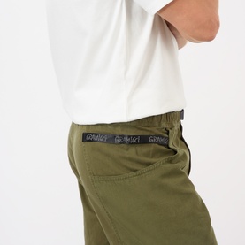 Model wearing Gramicci Gadget Belted Trousers in olive, with branded adjustable belt at waist, paired with white t-shirt.