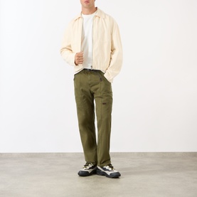 Model wearing Gramicci Gadget Belted Trousers in olive, straight-leg fit with adjustable belt, styled with cream zip jacket and trail trainers.
