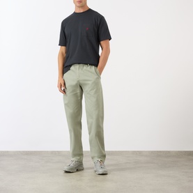Model wearing Gramicci G-Chinos in Dried Sage, straight-cut leg with elasticated waistband, styled with dark grey T-shirt and grey trainers.
