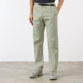 Model wearing Gramicci G-Chinos in Dried Sage, straight-cut leg with adjustable belt, styled with white chunky trainers.