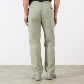 Model wearing Gramicci G-Chinos in Dried Sage, showing rear view with logo patch, elasticated waistband and straight-cut leg.