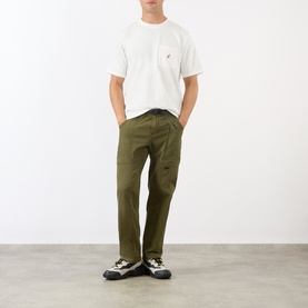 Model wearing Gramicci One Point Chest Pocket T-Shirt in white, styled with olive cargo trousers and chunky trail trainers.