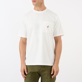 Model wearing Gramicci One Point Chest Pocket T-Shirt in white with small logo detail on chest pocket, paired with olive green trousers.