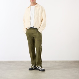 Model wearing Gramicci One Point Chest Pocket T-Shirt in White, styled with olive cargo trousers, cream jacket, and trail trainers.