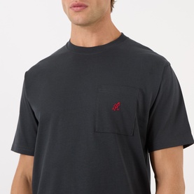 Model wearing Gramicci One Point Chest Pocket T-Shirt in black with red embroidered logo, crew neck, short sleeves and chest pocket.