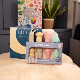 Set of five finger puppets in neutral and pastel tones, boxed, styled with a children's picture book on a cream textured surface