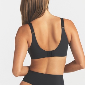 Model wearing Skims Full Cup Bra in black, rear view showing adjustable straps and smooth back panel, paired with black briefs.