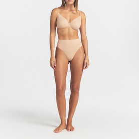Model wearing Skims beige Full Cup Bra with matching high-waist briefs, smooth seamless finish, minimal straps