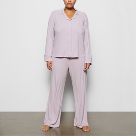 Model wearing Skims Pyjamas in Iris Mica, long-sleeve button-up top and wide-leg trousers in soft lilac-grey
