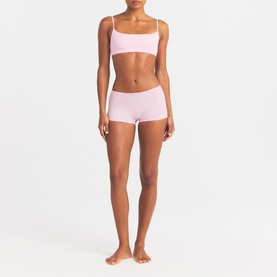 Model wearing pink seamless bralette and matching boy shorts set, styled together as coordinated underwear set