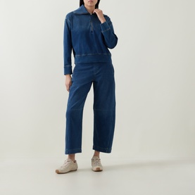 Model wearing Spanx Denim Barrel Leg Track Pants in dark blue, high-rise cropped fit with tobacco stitching