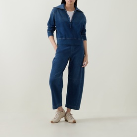 Model wearing Spanx Denim Barrel Leg Track Pants in dark blue, high-rise cropped barrel leg, styled with matching zip top and beige trainers