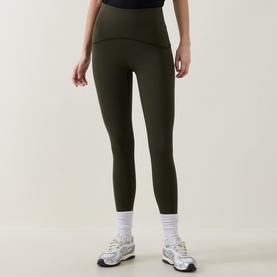Model wearing dark olive high-waist leggings, styled with white ankle socks and grey trainers