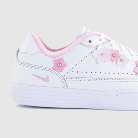 Nike white leather trainers with pink floral appliqu&eacute; detailing, pink swoosh logo, and white sole