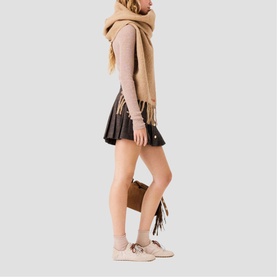 Model wearing Maje Womens French Dress in black mini skirt style, styled with camel scarf, beige top and lace-up ankle boots