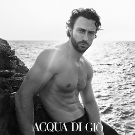 Armani Beauty Acqua di Gio Homme Eau de Parfum Intense campaign image, shirtless man by rocky coastal sea in black and white