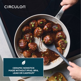 Circulon Halo LaserDefense Ceramic Frying Pan 30cm in white, filled with glazed meatballs, held over induction hob with tongs