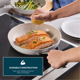 Circulon Halo LaserDefense Non Stick Ceramic Frying Pan 25cm in white, shown cooking salmon on induction hob with durable construction text overlay