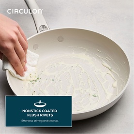 Circulon Halo LaserDefense&trade; Non Stick Ceramic Frying Pan 25cm in white, shown with spatula mid-stir, highlighting nonstick flush rivet interior.