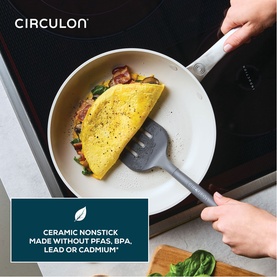 Circulon Halo LaserDefense&trade; 25cm ceramic non-stick frying pan in white, used on induction hob cooking an omelette with vegetables.