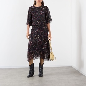 Model wearing Isabel Marant Etoile Frida Abstract Print Dress in black with flutter sleeves and midi length, styled with black cowboy boots and