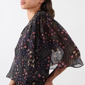 Model wearing Isabel Marant Etoile Frida Abstract Print Dress in black with floral pattern, short flutter sleeves and semi-sheer overlay