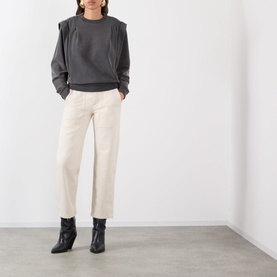 Model wearing Isabel Marant Etoile Soldy Structured Sweatshirt in Faded Black with structured shoulders, styled with cream trousers and black ankle