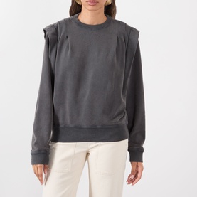 Model wearing Isabel Marant Etoile Soldy Structured Sweatshirt in faded black with dropped shoulders and pleat detail, styled with cream trousers.