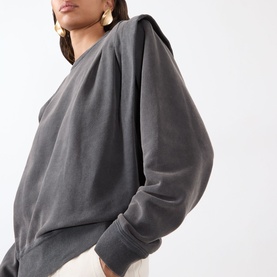 Model wearing Isabel Marant Etoile Soldy Structured Sweatshirt in faded black with dropped structured shoulders, long sleeves and ribbed trims