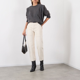 Model wearing Isabel Marant Etoile Soldy Structured Sweatshirt in Faded Black with cream straight-leg trousers, black ankle boots, and small black