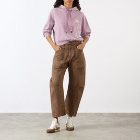 Model wearing Isabel Marant Etoile rosewood hoodie sweat with ecru logo, styled with brown wide-leg trousers and white trainers.