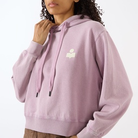 Model wearing Isabel Marant Etoile rosewood hoodie sweatshirt with ecru logo, drawstring hood, cropped fit, styled with khaki trousers.