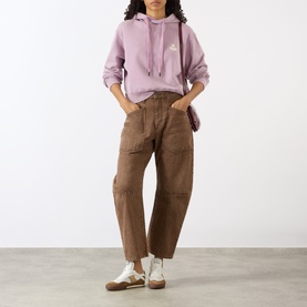 Model wearing Isabel Marant Etoile rosewood hoodie sweat, styled with brown wide-leg cargo trousers and white trainers.