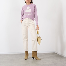 Model wearing Isabel Marant Etoile Millyny Logo Sweatshirt in Rosewood/Ecru, styled with cream wide-leg jeans, tan boots, and a small gold bag.