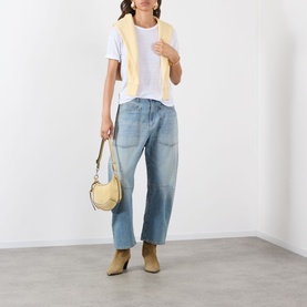 Model wearing Isabel Marant Etoile Koldia Logo T-Shirt in White/Pink, styled with yellow gilet, light-wash wide-leg jeans, tan boots, and a small