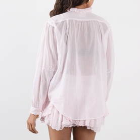 Model wearing Isabel Marant Etoile Leota Ruffle Blouse in light pink, back view, sheer voile fabric with gathered cuffs and ruffled hem shorts.