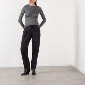 Model wearing Isabel Marant Etoile faded black cotton tapered trousers, styled with a grey long-sleeve top and black ankle boots.