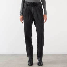 Model wearing Isabel Marant Etoile faded black cotton trousers with tie waist and pleat detail, styled with black ankle boots.