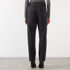 Model wearing Isabel Marant Etoile faded black cotton trousers, rear view, styled with black ankle boots and grey top.