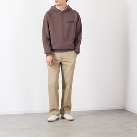 Model wearing Jacquemus brown cotton hoodie, styled with beige chinos and white trainers