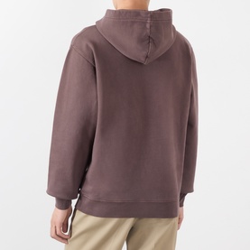 Model wearing Jacquemus brown cotton hoodie, rear view, oversized fit with hood detail, styled with beige trousers