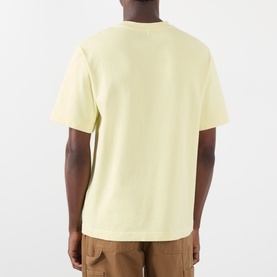 Model wearing Jacquemus The Gros Grain Logo T-Shirt in pale yellow, back view, styled with tan trousers