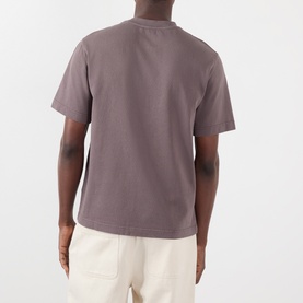 Model wearing Jacquemus brown cotton T-shirt, shown from behind, styled with cream trousers