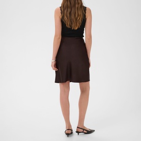 Model wearing Kaffe Coffee Bean mini skirt, styled with black sleeveless top and black kitten heel mules, rear view.