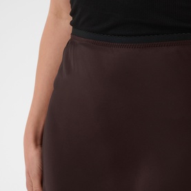 Model wearing Kaffe Coffee Bean satin mini skirt with black sleeveless top, close-up detail of waistband and fabric.