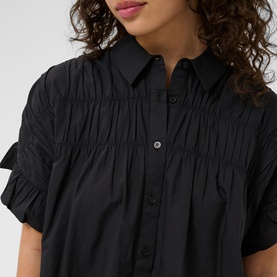 Model wearing Kaffe black deep short sleeve shirt dress with ruched bodice detail and button-front placket, cropped view