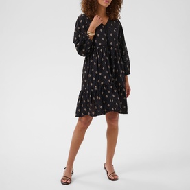 Model wearing Kaffe black gray vintage baroque print tiered mini dress with long sleeves, styled with tan strappy heeled sandals